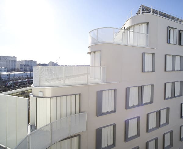 Fachada de edificio moderno con barandillas metálicas blancas fabricadas por Talleres Montes