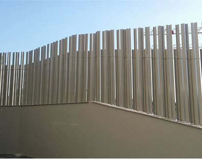 Cerramiento metálico perimetral con lamas verticales de diseño moderno