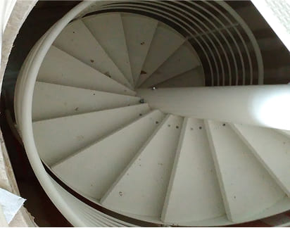 Escalera de caracol metálica pintada en blanco para interior de vivienda