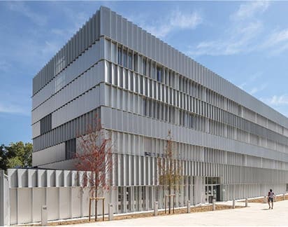 Fachada de colegio moderno con estructura metálica exterior