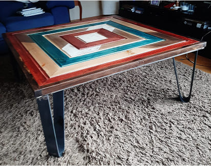 Mesa metálica con tablero de madera en diseño geométrico y colores vivos