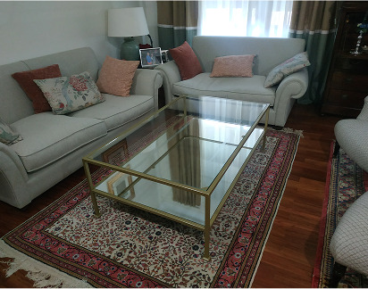 Mesa de salón rectangular con estructura metálica dorada y sobre de cristal