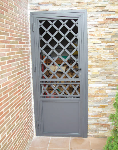 Puerta metálica con reja decorativa de diseño cruzado en acceso lateral